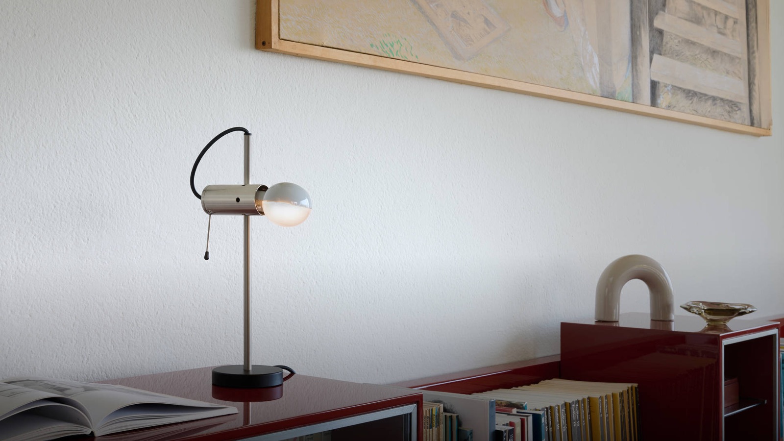 Oluce Agnoli Tischleuchte vor grauem Hintergrund